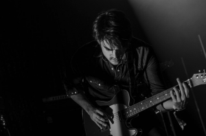 B&W photo of man playing guitar - why people quit learning guitar