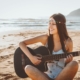smiling hippie girl playing guitar