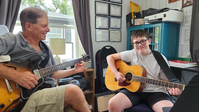 Dennis Winge with guitar student in lesson